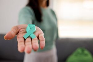Woman Holding Teal Ribbon for January Cervical Cancer Awareness Month. Woman Holding Teal Ribbon for January Cervical Cancer Awareness Month.